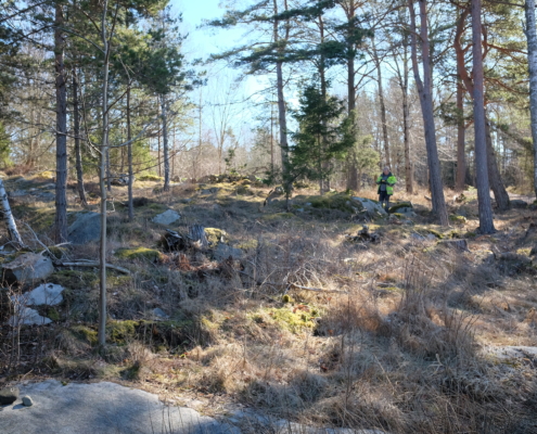 En översiktsbild över ett område med stenbrott och hägnad, beläget i utredningsområdets nordvästra del. Foto mot öst.